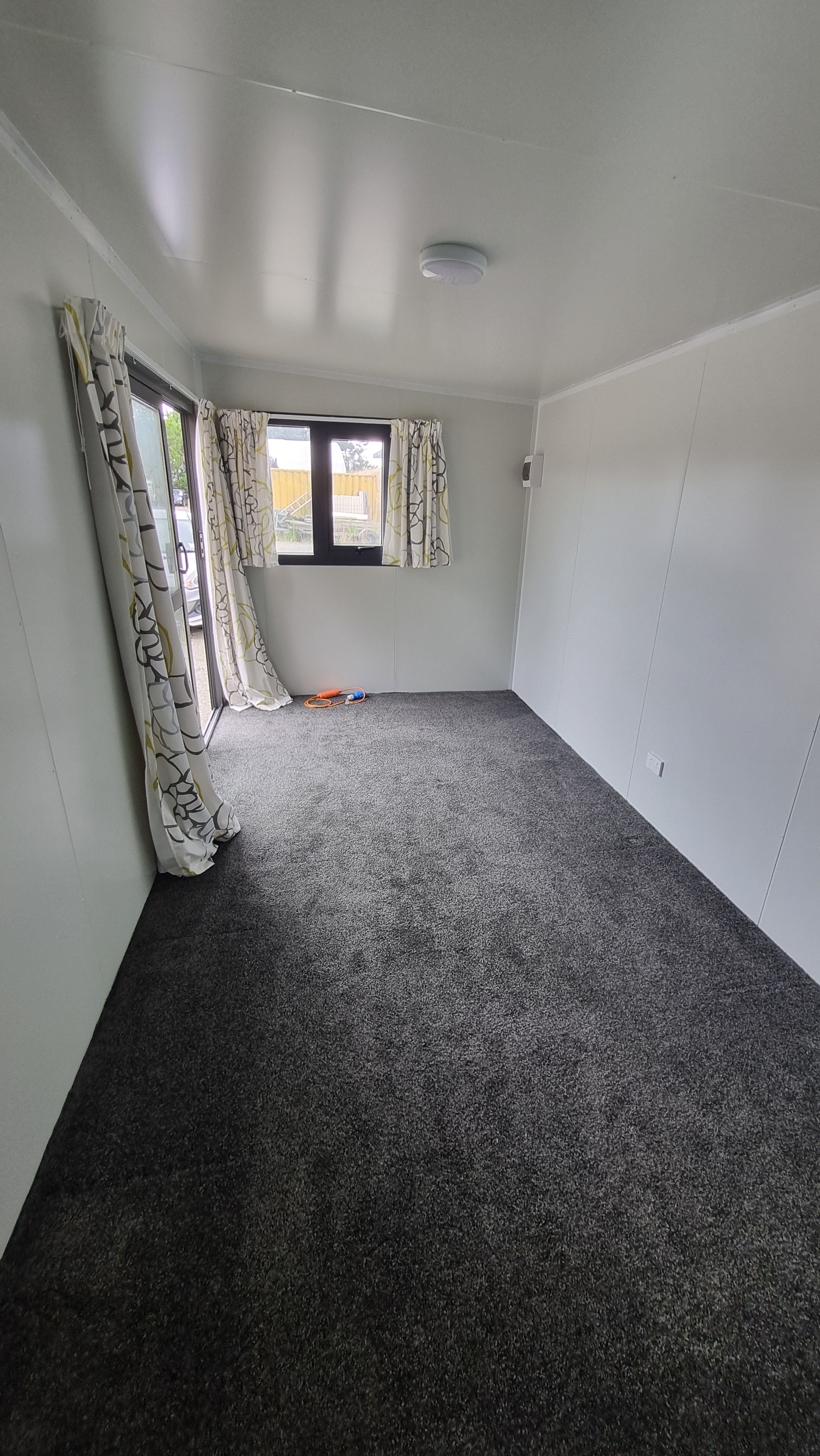 Empty cabin interior showing carpet and windows