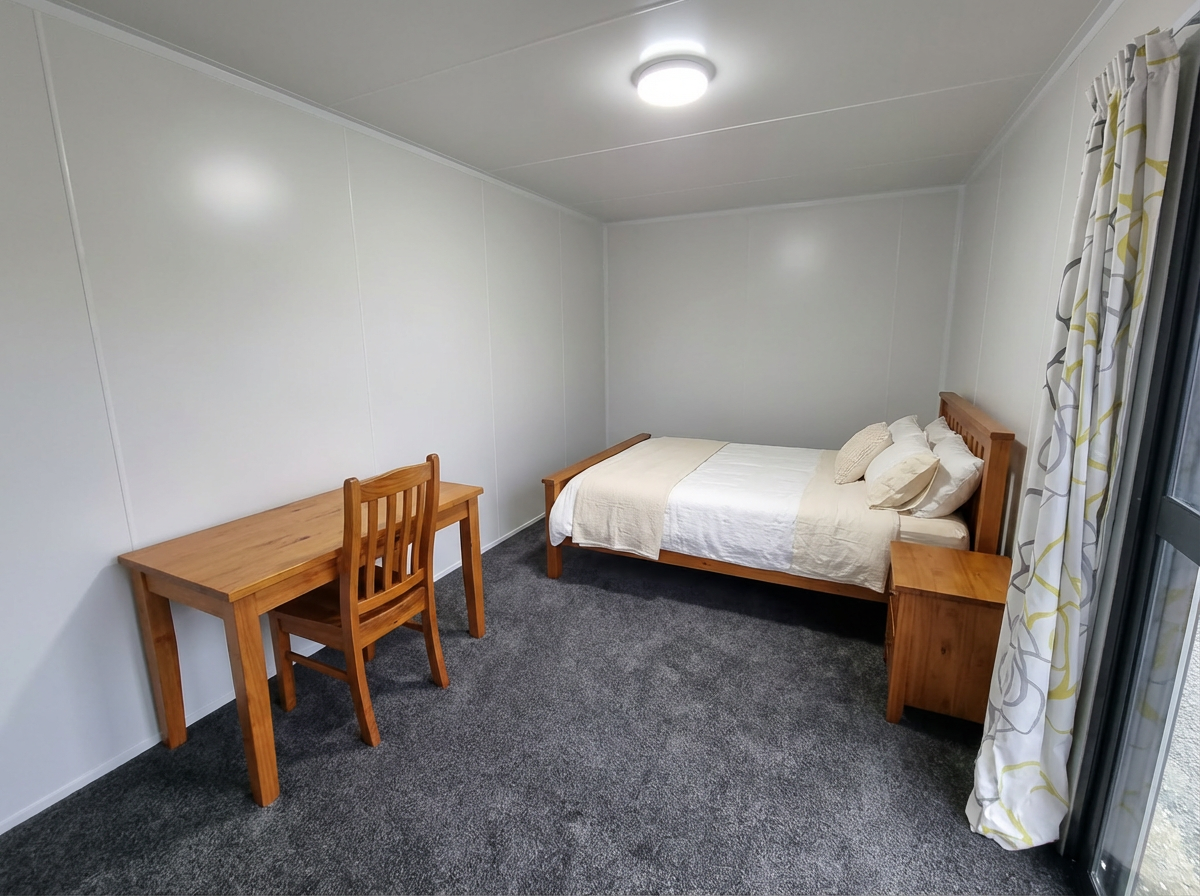 Cabin interior with queen bed, desk and chair